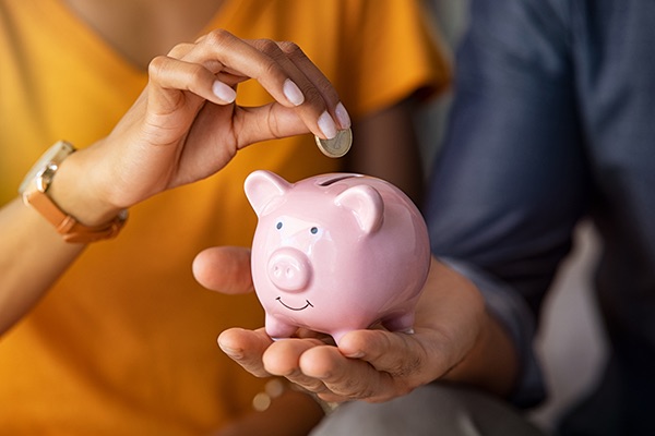 Couple Puts Coins in Piggy Bank | Benefits of Quitting Drinking