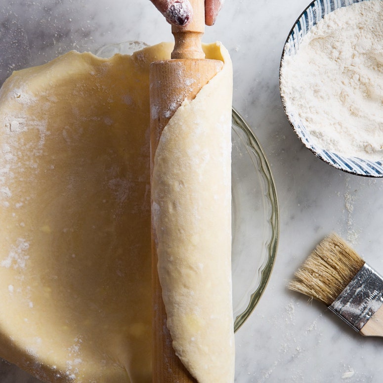 Pie dough being transferred to a pie dish