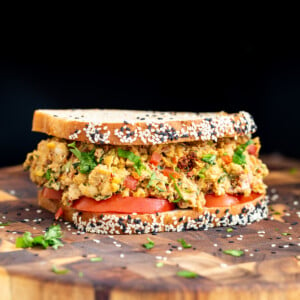 Mediterranean chickpea salad sandwich on a wooden board