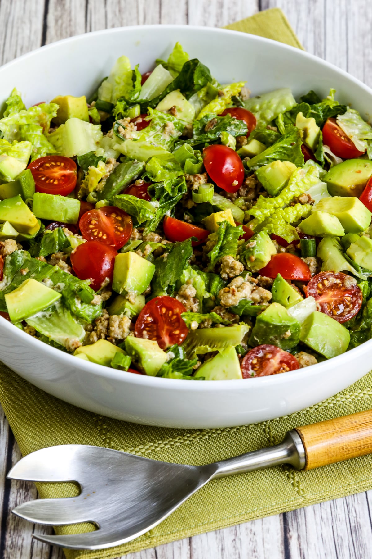 Ground Turkey Taco Salad with Salsa Verde shown in serving bowl with spoon.