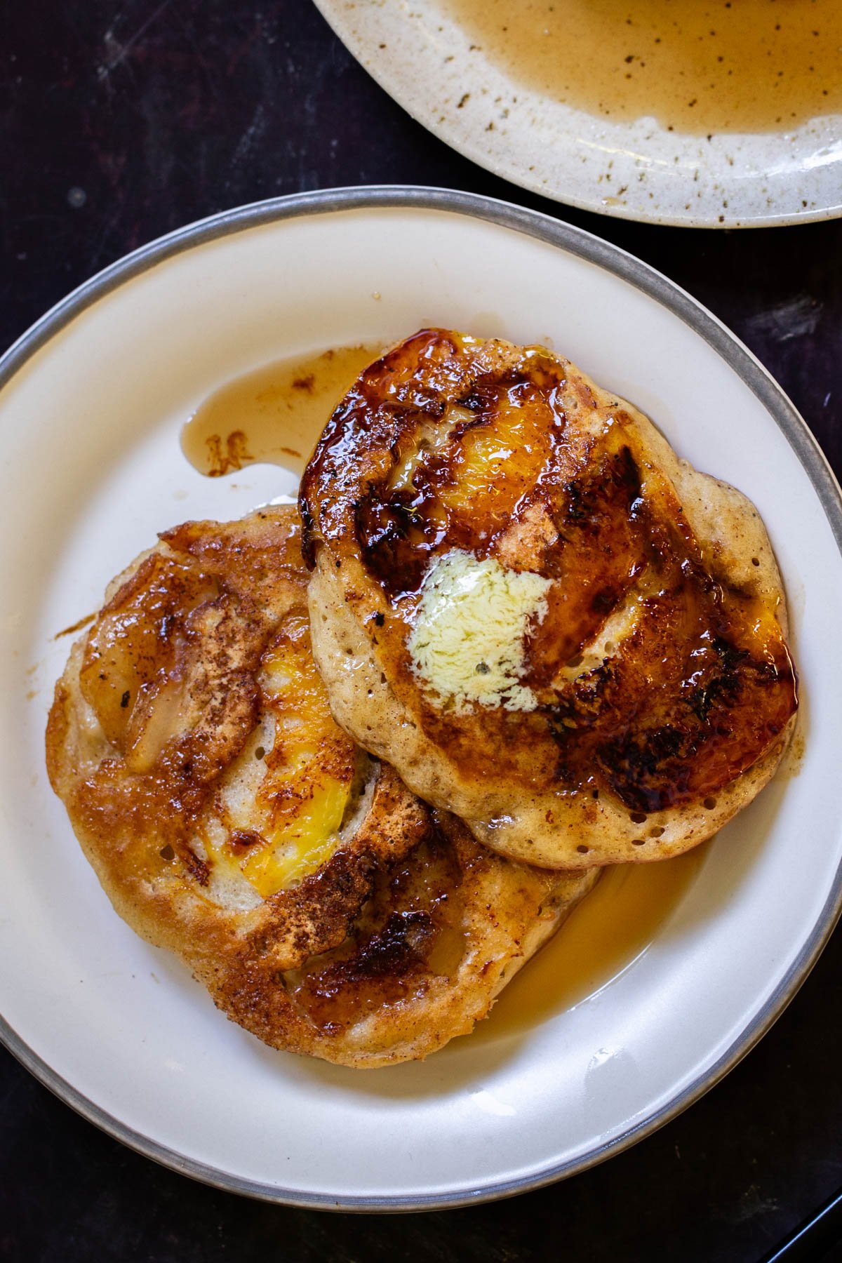 a plate of peach upside-down pancakes with a piece cut out, so you can see the fluffy inside