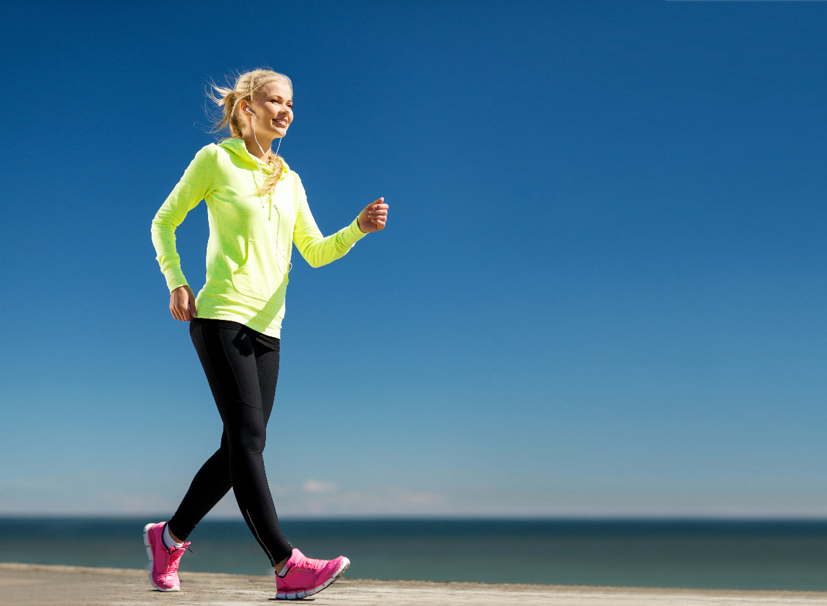 woman power walking by water