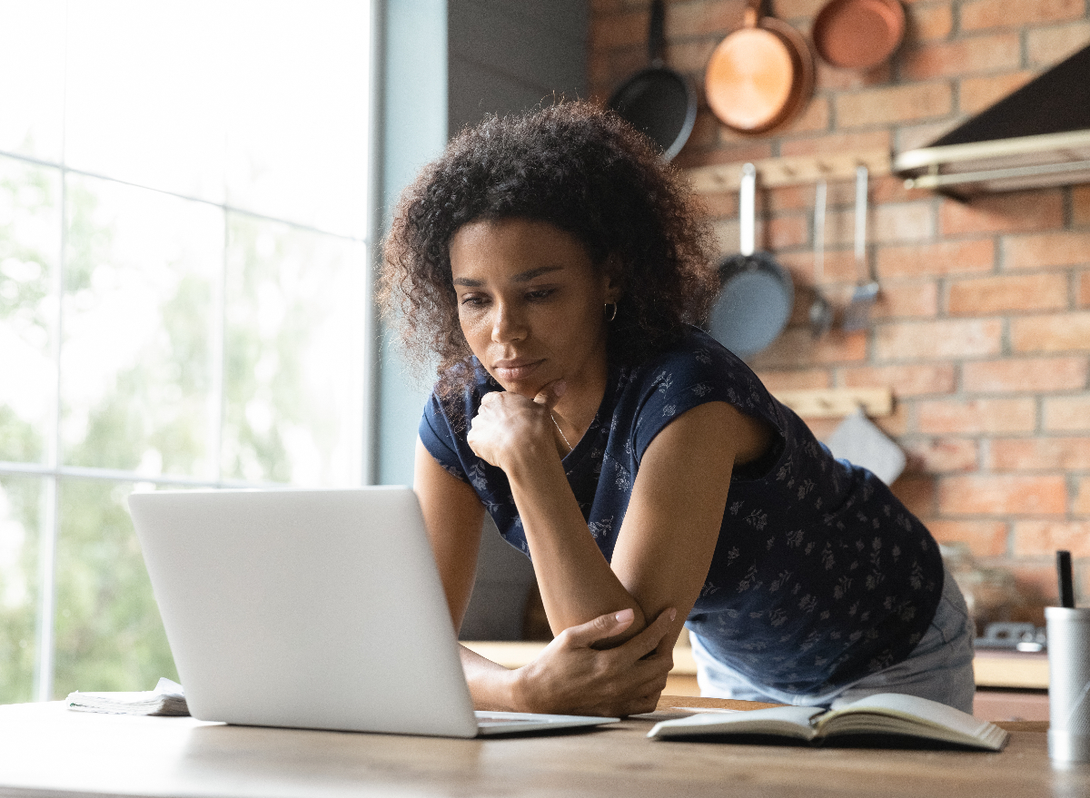 woman tuning into virtual event in her kitchen