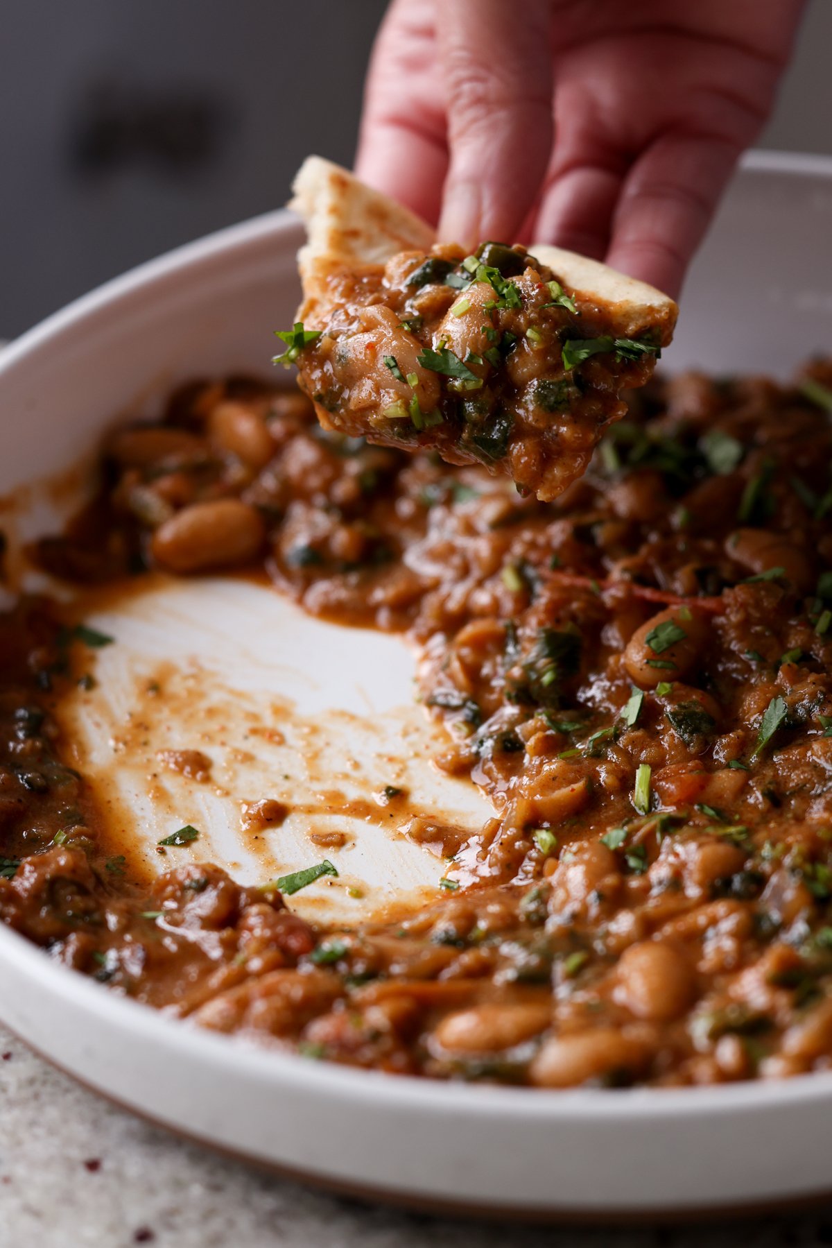 and scooping up some lentil bean stew on a piece of flatbread