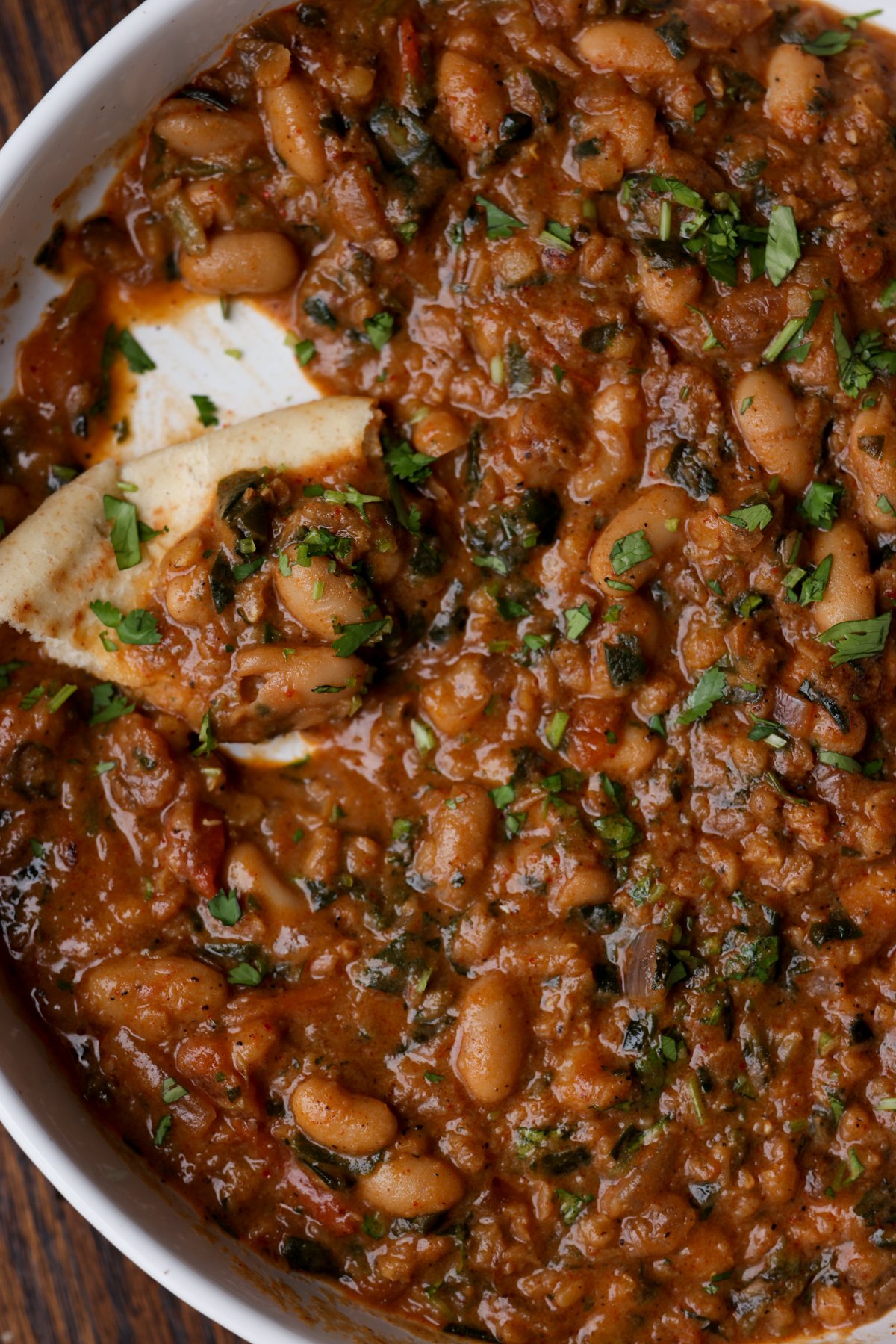 flatbread piece in a bowl of lentil bean stew