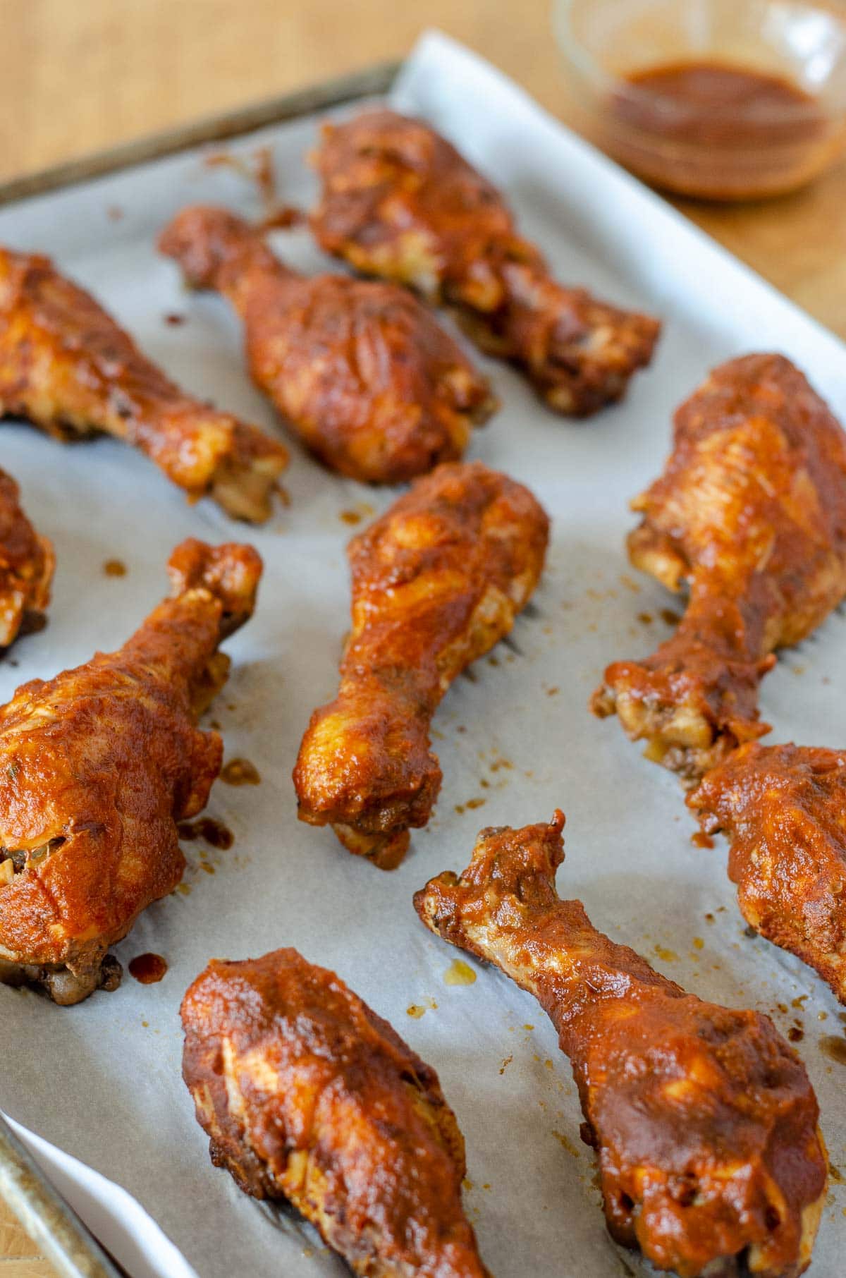 BBQ chicken drumsticks on baking sheet lined with parchment paper.
